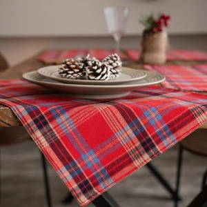 Festive red and blue plaid table runner on wooden table with holiday decor