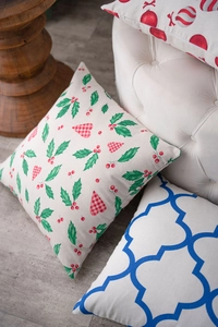 Detail of Christmas pillow cover featuring holly leaves and red berry festive pattern