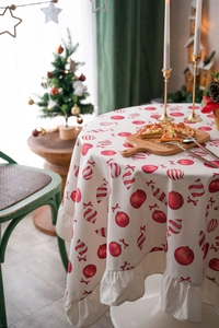 Close-up of ruffled edges on Christmas round tablecloth with red candy ball print