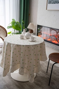 Close-up of beige round tablecloth with lemon prints and ruffles in a cozy home setting
