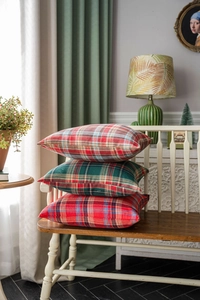 Macro shot of layered British vintage style plaid pattern cushion covers on a wooden bench