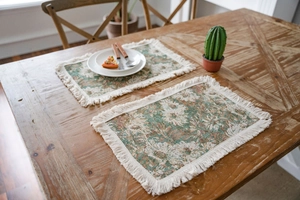 Dettaglio delle tovagliette in jacquard vintage a rose con eleganti nappe color crema