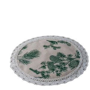 Linen table mat with pine branch print, bird motif, and delicate white lace trim edge