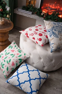 Set of four festive cushion covers with Christmas and geometric patterns on a white ottoman