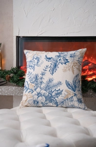 Detail view of blue and gold botanical Christmas pillow cover on a white bench