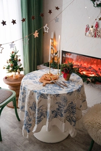 Detail of elegant ruffled edge table cloth with blue floral print in Christmas setting