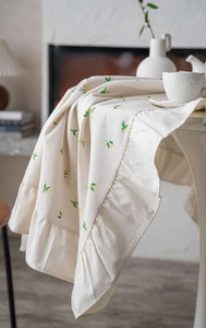 Detail of ruffled edges and lemon print on cotton linen rectangular tablecloth