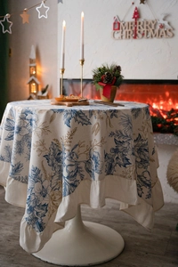 Detailed view of round tablecloth with pine cone print and elegant ruffled edge details