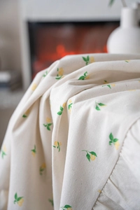 Macro shot of rustic tablecloth fabric with vibrant lemon print and soft ruffled edges