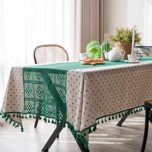 Blue daisy pattern tablecloth with green lace patchwork and tassels in rustic style