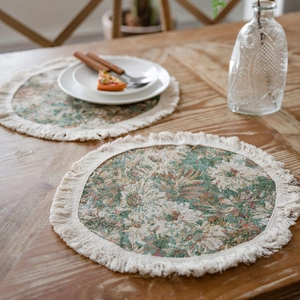 Sottopiatto vintage jacquard con frange su un tavolo da pranzo in legno chiaro