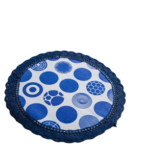 Elegante tovaglietta rotonda con pizzo e motivi geometrici blu e bianchi su bianco