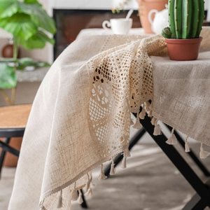 Minimalist beige linen tablecloth with crochet lace and small tassels in a Nordic style