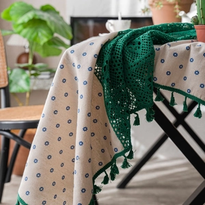 Rural style beige tablecloth with blue floral pattern and green lace fringe detail