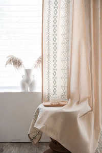 Detail eines Vorhangs im Boho-Stil aus beigem Baumwollleinen mit grünem Print und Quasten