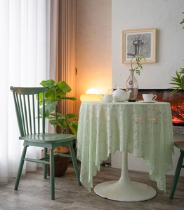 Detail of light green lace tablecloth featuring delicate pearl edges and floral patterns