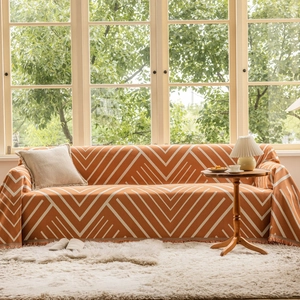 Modern orange geometric sofa cover with white V-patterns and elegant short tassels