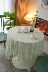 Detailed macro view of mint green lace tablecloth with elegant beadwork and crochet patterns