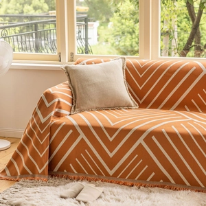 Detailed view of orange and white herringbone knit fabric with elegant tassel fringe