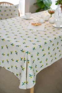 Detail of floral embroidery on cream cotton linen tablecloth with a rustic aesthetic