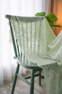 Detail of light green lace tablecloth with floral embroidery and white pearl beads