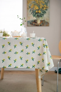 Close-up of floral embroidery detail on cream-colored linen tablecloth fabric