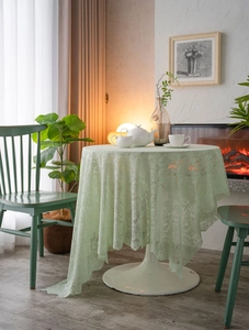Close-up of light green floral lace tablecloth with elegant white pearl bead edge detail