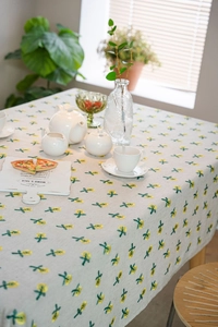 Detail of floral embroidery on light beige linen tablecloth with rustic pattern texture