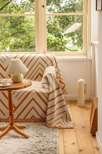 Detailed shot of chevron pattern throw blanket with orange and white fringe edges