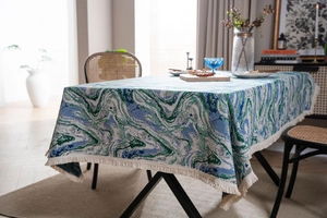 Detailed texture of green ink jacquard tablecloth with elegant white fringe tassel edge
