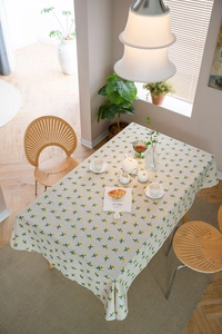 Detail shot of cotton linen tablecloth featuring bright yellow floral embroidery patterns