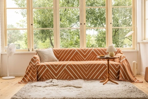 Close-up of orange geometric V-pattern throw blanket with delicate fringe trim