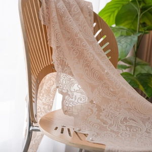 Detail view of lace tablecloth featuring floral embroidery and white pearl trimmings