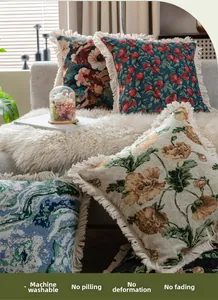 Détail de housses de coussin en jacquard vintage avec d'élégantes franges à pompons crème
