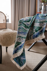 Close-up of green oil painting style jacquard tablecloth with delicate fringe detail