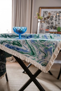 Detail of green watercolor jacquard tablecloth featuring thick fabric and beige tassels