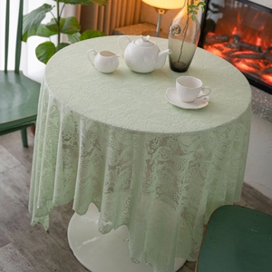 Elegant mint green lace tablecloth with floral crochet patterns on a round dining table