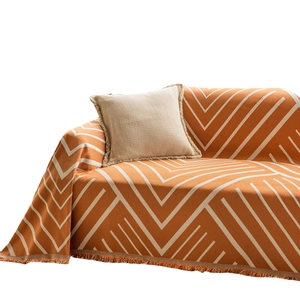 Modern orange and white geometric herringbone sofa cover with decorative fringe edges