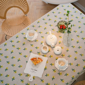 Floral cotton linen tablecloth with mimosa embroidery on rectangular dining table
