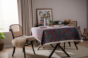 Close-up of navy blue rectangular tablecloth with red apple jacquard and tassel edges