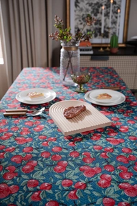 Close-up of jacquard tablecloth with apple pattern and a grooved wooden serving tray