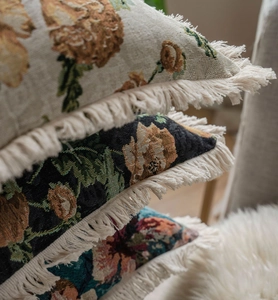 Gros plan d'un coussin décoratif tissé avec des franges bohèmes et un motif floral