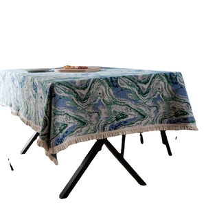 Green marble pattern tablecloth with white fringe trim on a modern dining table