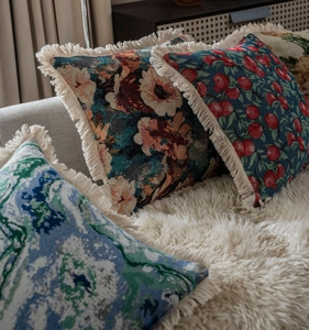 Détails de coussins en jacquard vintage avec motifs floraux et franges crème