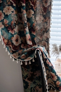 Detail view of vintage floral jacquard fabric with elegant cream fringe tassels