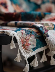 Detail of woven tapestry curtain featuring retro floral patterns and cream fringe tassels