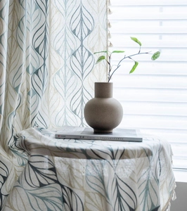Detail of Nordic leaf print cotton linen curtain with decorative white tassels trim
