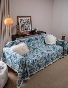 Close-up of abstract marble pattern woven sofa cover with decorative fringe trim