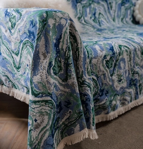 Close-up of retro floral jacquard sofa throw with fringe and marble texture