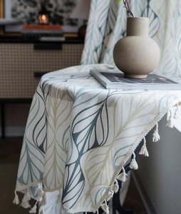 Detailed macro view of retro geometric leaf print cotton linen fabric with beige tassels